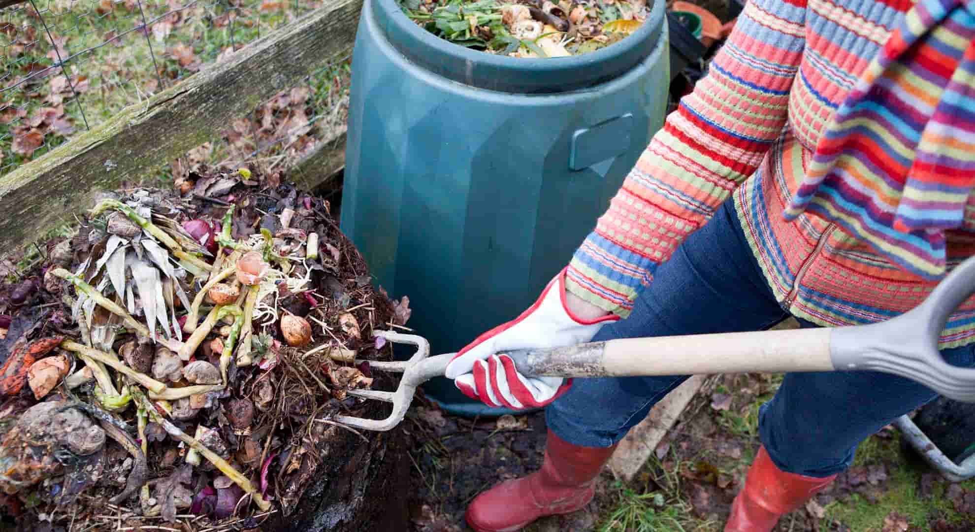 Photo of a person aerating compost pile with a garden fork