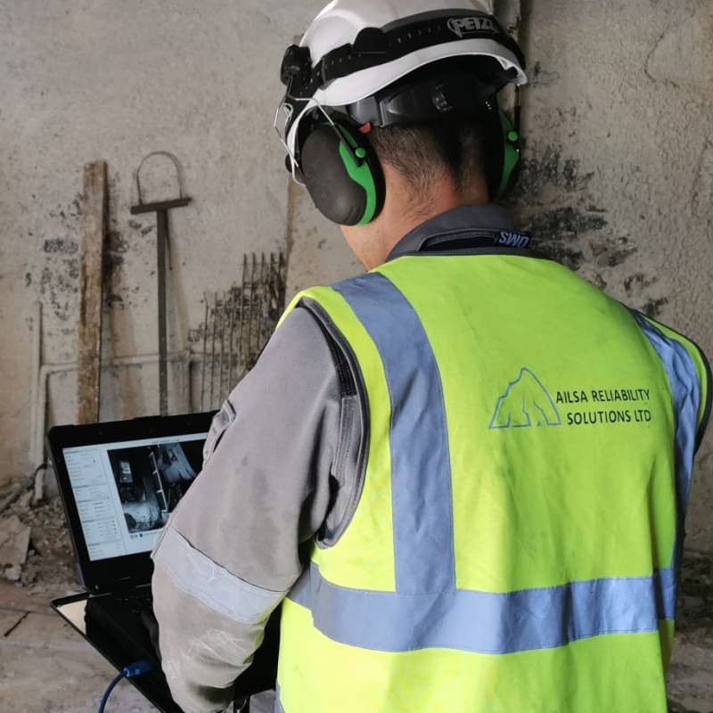 Ailsa Reliability worker in hi-vis on site with laptop
