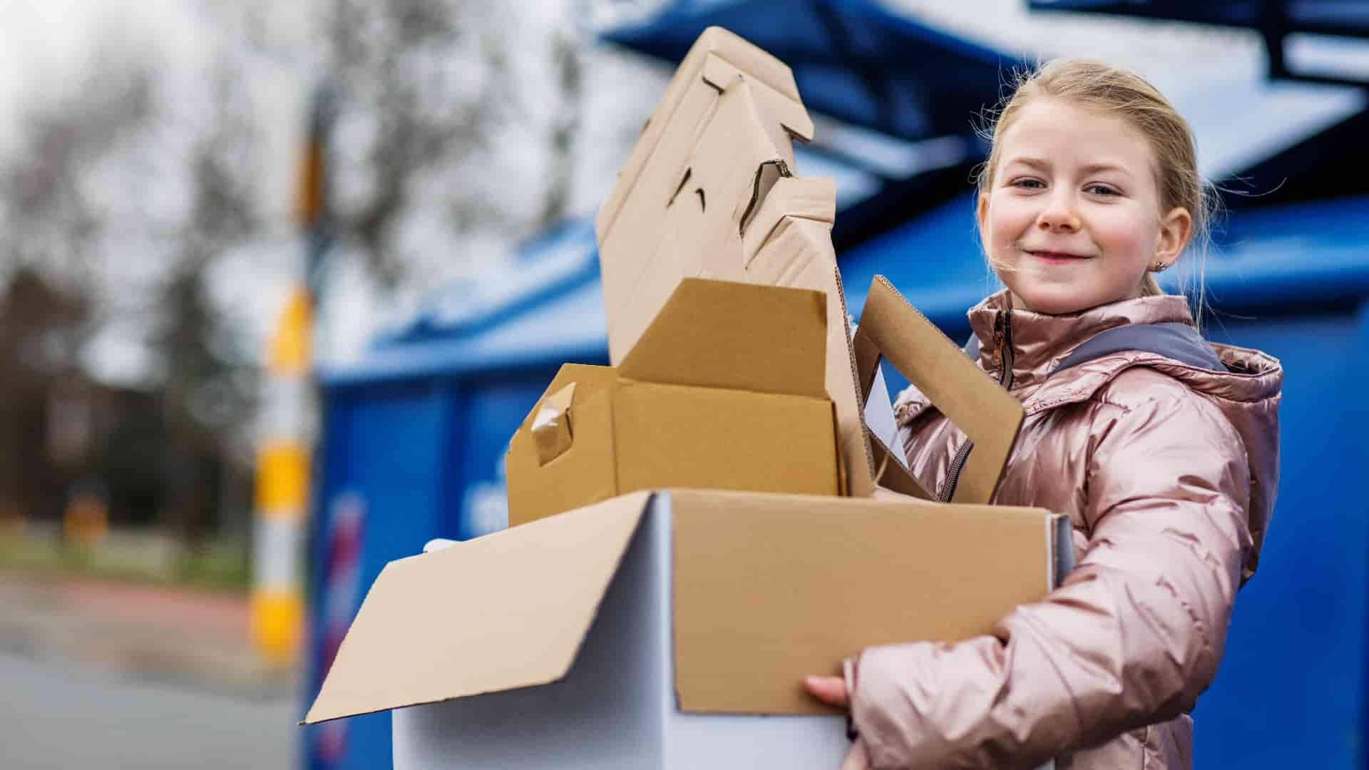 Young person carrying cardboard for recycling