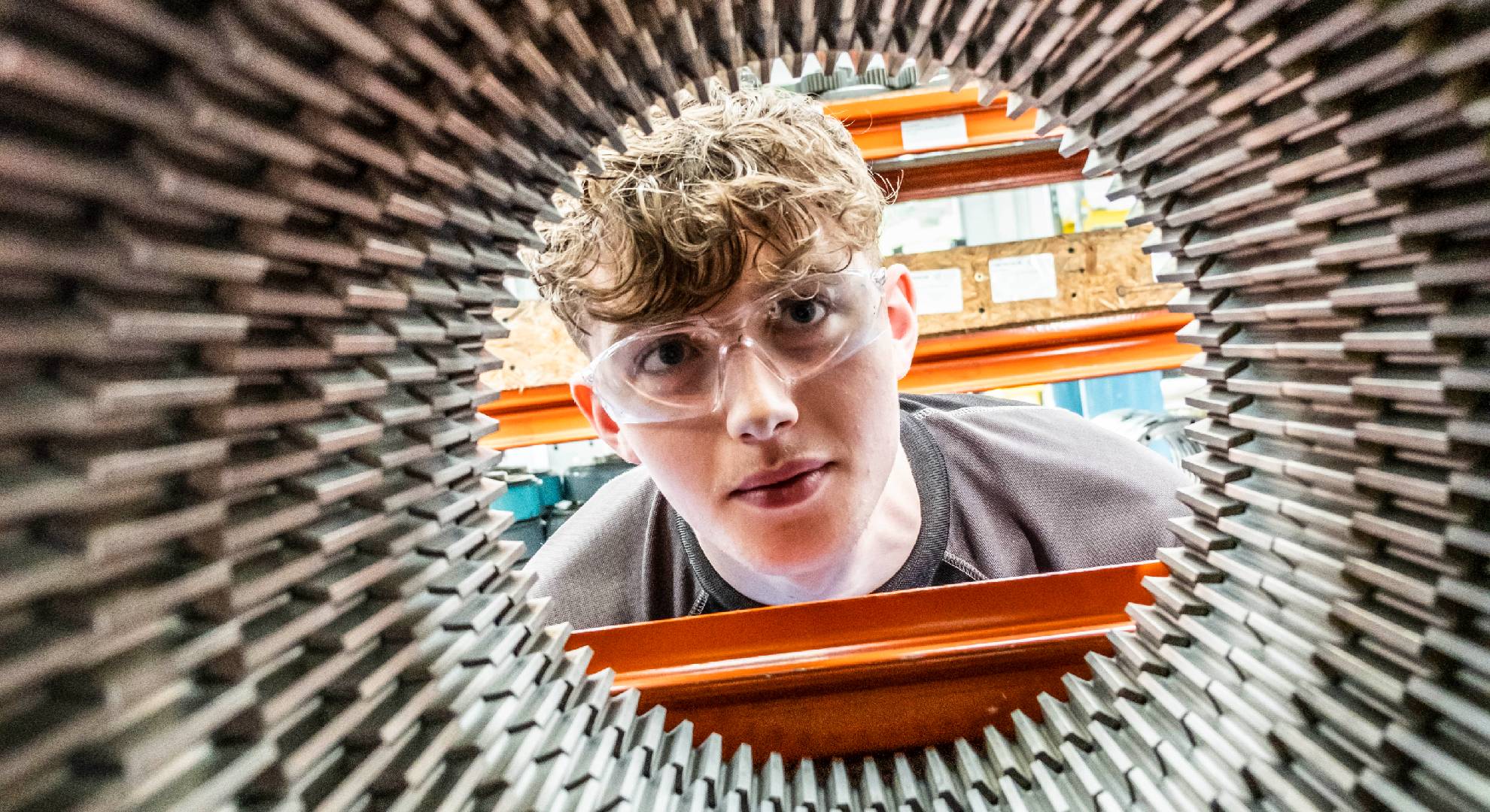 Man looking through cylinder 