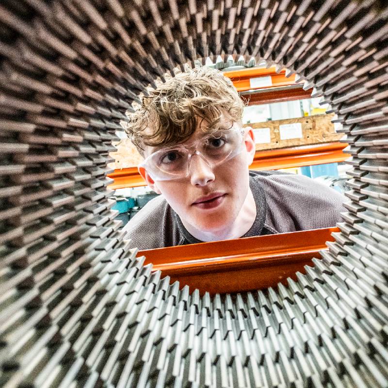 Man looking through cylinder 